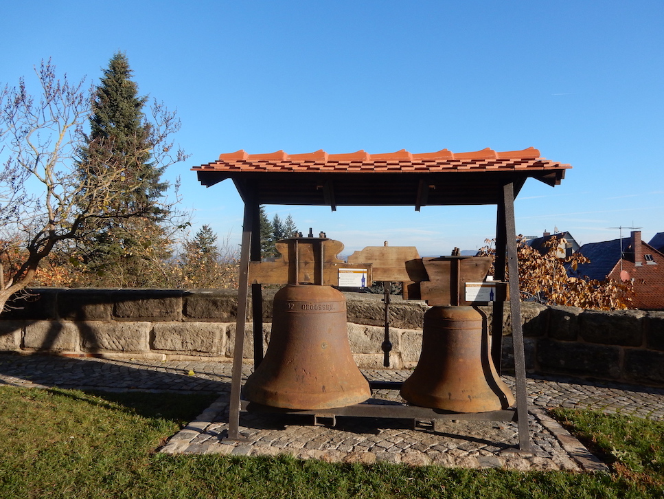 Überdachte alte Kirchenglocken, ausgestellt im Kirchgarten