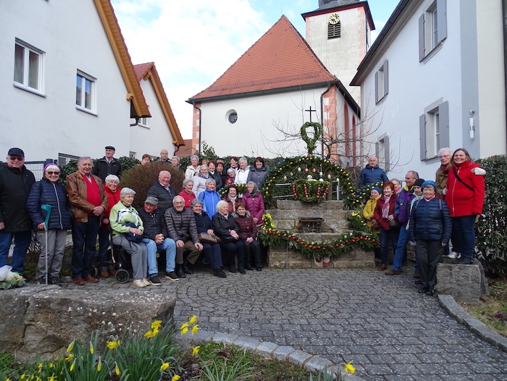 Gruppenfoto vor Osterbrunnen mit Kirche im Hintergrund