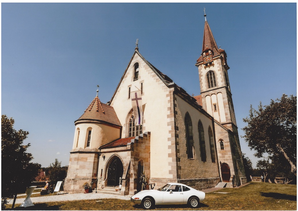 Sonniger Tag, Hochzeitsauto im Kirchgarten