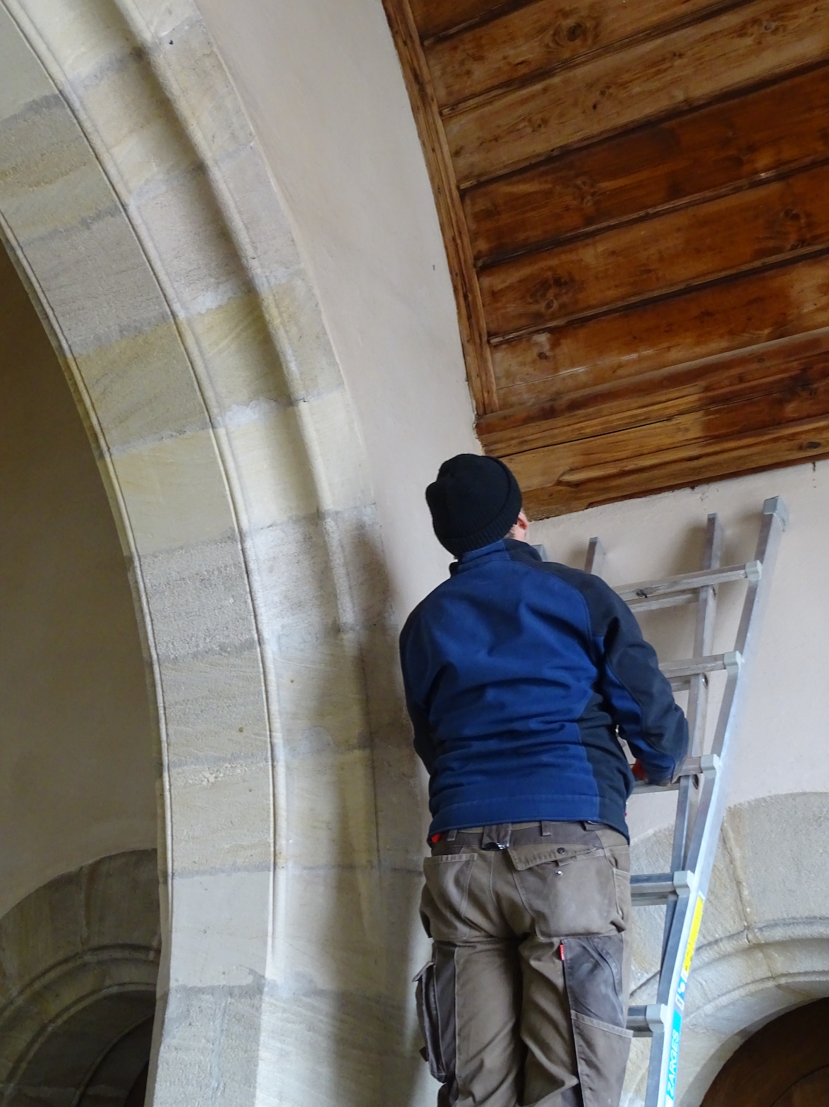 Handwerker inspiziert Holzdecke